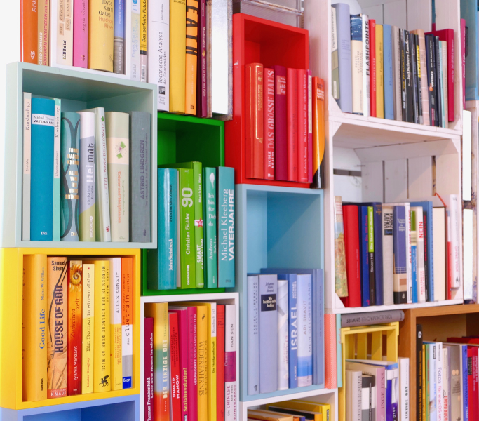 Estanteria plena de llibres organitzats per colors